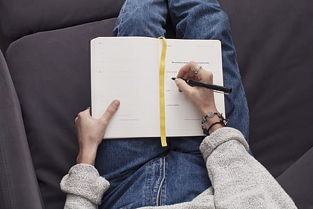 person writing on book thumbnail