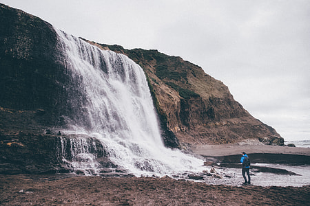 man standing near the waterfalls thumbnail