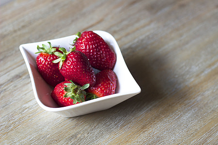 five Strawberries on top of white ceramic bowl plate thumbnail
