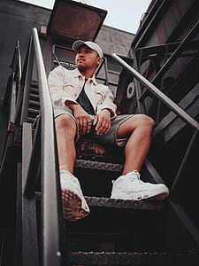 man sitting on black steel stair thumbnail