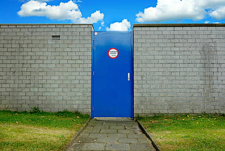 closed blue door near gray brick walls thumbnail