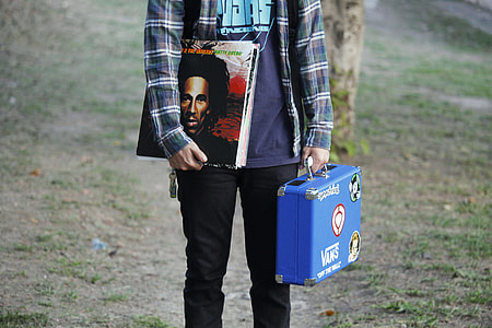 person holding magazine and blue case thumbnail