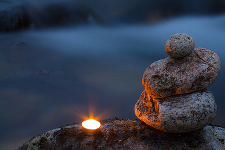 three gray rocks beside silver candle holder thumbnail