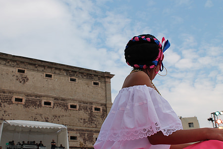 low angle photo of woman in pink off-shoulder top near building under blue sky thumbnail