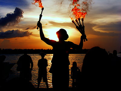 silhouette of person holding torch with flames thumbnail