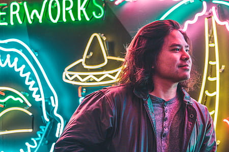 Man Standing in Front of Neon Signages thumbnail