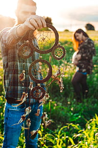 person holding brown dreamcatcher thumbnail