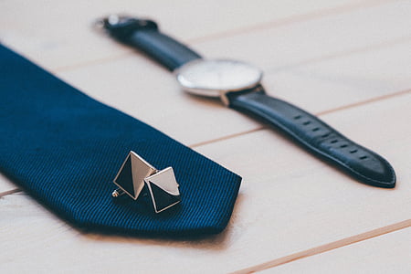 round silver-colored watch near black cufflinks and blue encktie thumbnail