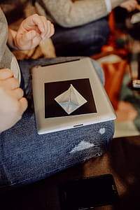 Women folding sheet of paper while making origami thumbnail