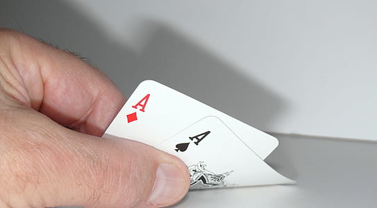person holding two ace of diamond and spade playing cards thumbnail