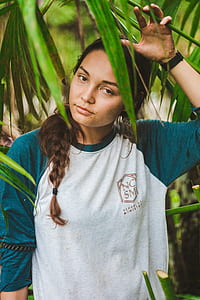 woman holding palm leaf during daytime thumbnail