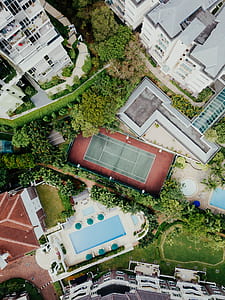 bird's-eye view of tennis court between building and pool thumbnail