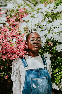 woman standing near pink and white flower at daytime thumbnail