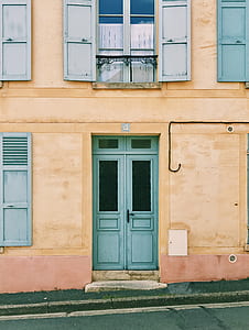 blue wooden door in beige building thumbnail