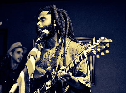 grayscale photography of man playing guitar thumbnail
