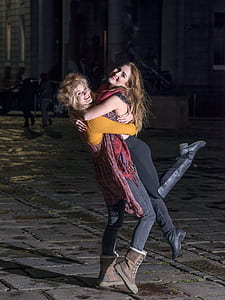 woman carrying woman at the middle of road thumbnail