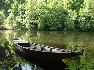brown canoe boat on body of water thumbnail