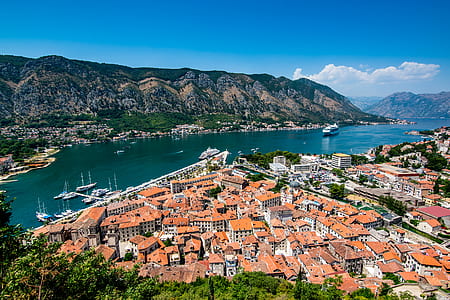 buildings near sea and mountains at daytime thumbnail