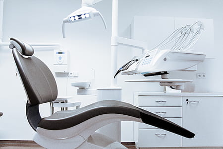 black and white medical chair beside white digital machine inside room thumbnail