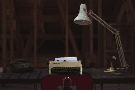 white gooseneck lamp beside type writer thumbnail