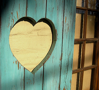yellow wooden heart hung on wall thumbnail