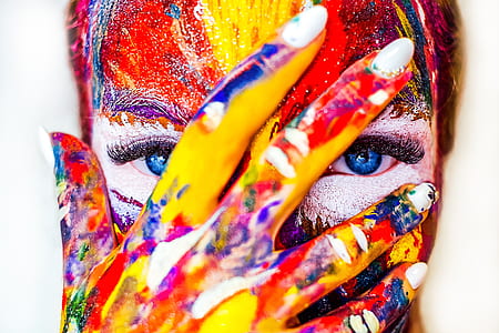 person filled with body painting with her hand on her face thumbnail