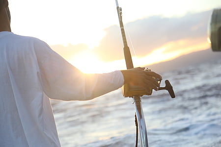 man holding black and brown fishing rod thumbnail