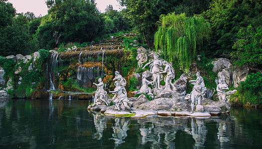 group of people standing statues beside water thumbnail