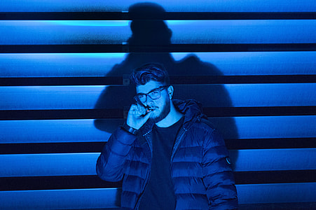 man with eyeglasses biting his thumb while looking sideways thumbnail