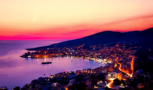 cityscape near body of water in areal photography during golden hour thumbnail