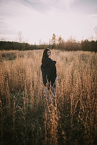 woman standing in brown grass field thumbnail