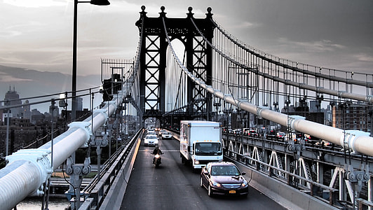 assorted vehicles running on gray concrete bridge under gray sky during daytime thumbnail