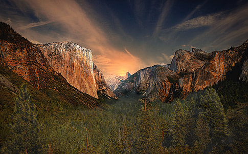green forest surrounded by mountains during daytime thumbnail