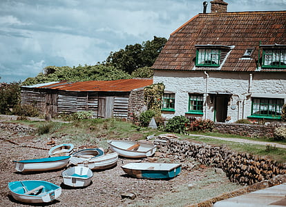 white-and-blue jon boats in front of white concrete house thumbnail