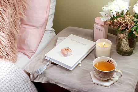 white teacup beside white petal flowers thumbnail