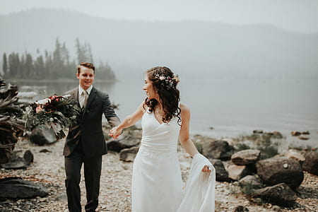 new wed couple walking beside body of water thumbnail
