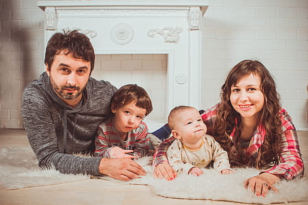woman and man holding toddlers lying on rug thumbnail