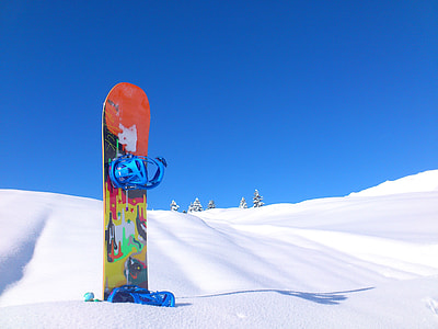orange and yellow snowboard on snow thumbnail