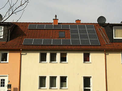 white and brown house with solar panel boards on top of roof thumbnail