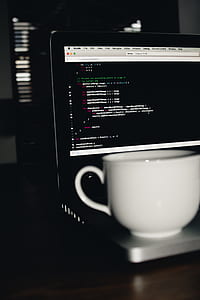 white ceramic teacup on turn on laptop computer thumbnail