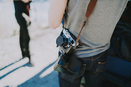 person carrying DSLR camera on his side thumbnail