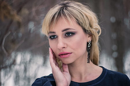 selective photography of woman holding face thumbnail