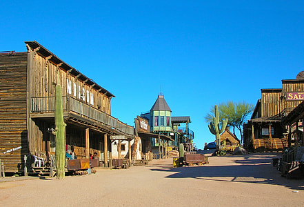 green and brown wooden houses near green cactus plants during daytime thumbnail