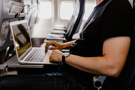 Unrecognizable man with notebook sitting inside an airplane thumbnail