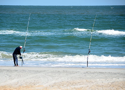 man standing beside fishing rod thumbnail