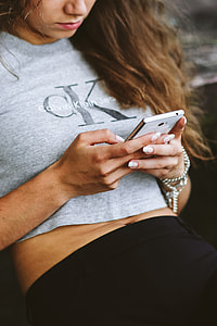 Young woman holding the white mobile phone thumbnail