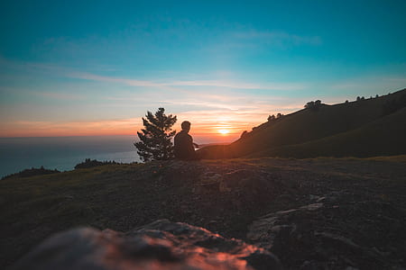 silhouette of person under sunset sky thumbnail
