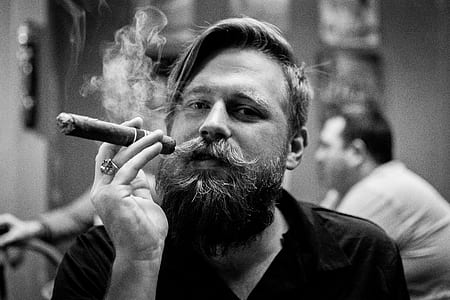 grayscale photography of man smoking cigar thumbnail