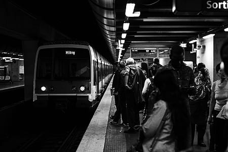 grayscale photography of people waiting the train thumbnail