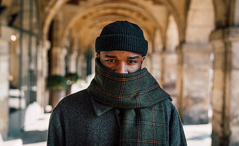 man wearing black knit cap and plaid scarf looking straight thumbnail